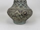a vase that is sitting on a white surface