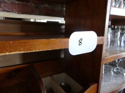 une étagère en bois sur laquelle sont posés des verres à vin et d'autres objets
