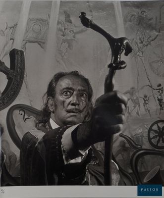 black and white photograph of a man holding a gun in front of a painting