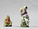 deux figurines représentant un homme et une femme assis sur une souche d'arbre
