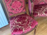 une paire de fauteuils rembourrés roses et dorés dans un salon