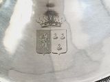a silver plate with a crown on it on a table