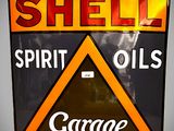 un panneau sur lequel est inscrit « Shell Spirit Oils Garage »