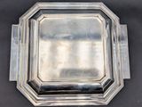 an antique silver plate on a black surface with a mirror in the middle