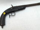gros plan d'un pistolet sur une table à fond blanc