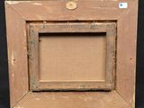 an old wooden picture frame with a button on it