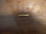 un petit objet métallique posé sur une table en bois