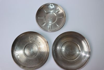 trois bols en métal argenté posés sur une surface blanche