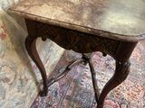 une petite table en bois avec un plateau en marbre, posée sur un tapis