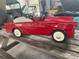 a red toy car sitting on top of a picnic table