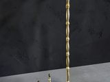 une paire de bougeoirs en laiton posés sur une table, sur fond noir