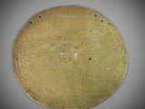 a close up of a gold plate with writing on it