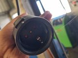 a person holding a black electrical plug in a garage