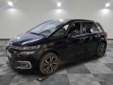 un monospace noir garé sur un sol à damier dans un garage