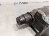 a close up of a drill on a table with a piece of metal