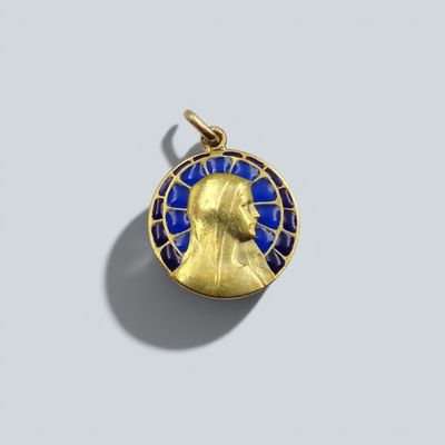 un pendentif en émail doré et bleu représentant une tête d'homme