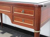 a wooden desk with a glass top on a checkered floor