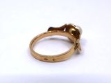 a gold ring with a flower on it on a white surface