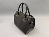 a black handbag with a braid handle on a white surface