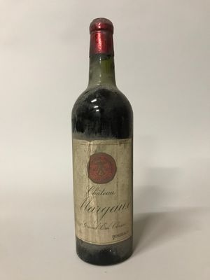 une vieille bouteille de vin posée sur une table blanche