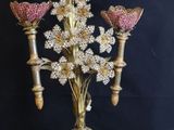 a gold candelab with pink flowers on it