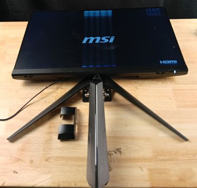 un ordinateur portable posé sur un trépied, sur une table