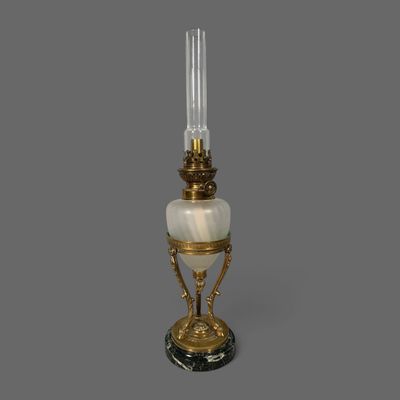 une lampe à l'ancienne surmontée d'un abat-jour en verre
