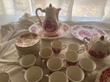 many cups and saucers on a table with a teapot