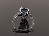 a close up of a ring with a blue sapphire and diamonds