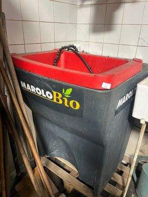 a red and black trash can sitting in the corner of a room