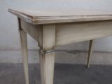 a small table with a wooden top on a cement floor