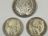 three silver coins with a woman ' s head and a man ' s head