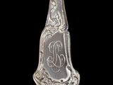 an antique silver spoon with a monogram on it on a black background
