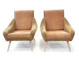 pair of mid century style lounge chairs with upholstered cushions