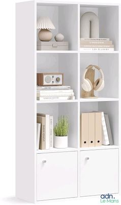 a white bookcase filled with books and a plant