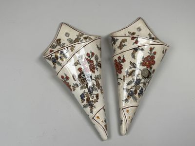 une paire de vases décoratifs ornés de motifs floraux, posés sur une table