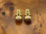 deux paires de boucles d'oreilles en or posées sur une table en bois