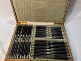 un coffret en bois contenant un ensemble de couteaux
