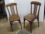 deux chaises en bois assises l'une à côté de l'autre dans une pièce