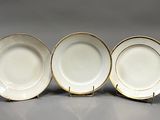 trois assiettes en porcelaine blanche et dorée, avec des bords dorés