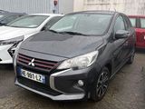Plusieurs voitures sont garées sur un parking situé devant un immeuble.