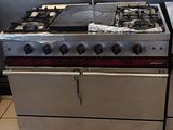 une cuisinière et un four dans une cuisine au sol carrelé