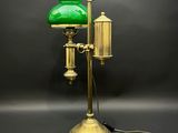 une lampe de table ancienne en laiton avec un abat-jour en verre vert sur fond noir
