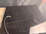 a black stove top with a black burner and a wire connected to it