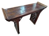 a wooden table with a carved top and a wooden base