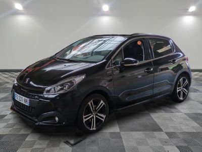 Une voiture noire est garée dans un garage dont le sol est à damier.