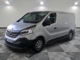 La camionnette argentée est garée sur un sol à damier dans un garage.