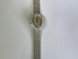 un gros plan d'une montre sur une surface blanche avec un fond blanc