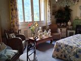 une chambre avec un lit, une chaise, une table et un lustre