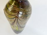 a brown and green vase sitting on a white surface